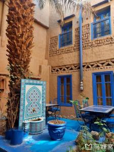 eine Terrasse mit einem Tisch und Stühlen sowie ein Gebäude in der Unterkunft Chez Youssef in Merzouga