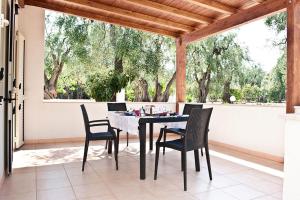 a table and chairs on a patio with trees at Felicity Vieste in Vieste