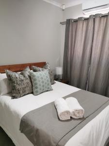 a bedroom with a bed with two towels on it at Rosedene in Bloemfontein +61 photos