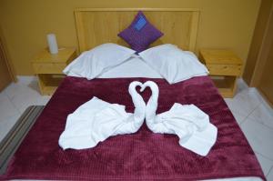 two swans made out of towels on a bed at LT Aparthotel in Praia