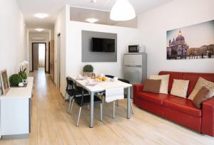 a living room with a red couch and a white table at Internazionale - Family Village in Sottomarina