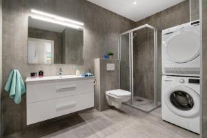 a bathroom with a toilet sink and a washing machine at Keyser Apartments 6 in Bergen