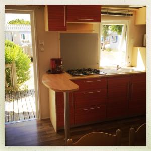 a kitchen with a counter and a sink and a stove at Camping Barataud in Saint-Denis-dʼOléron