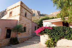 un edificio con flores rosas a su lado en Cala Dell'Arena, en Macari