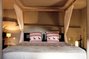 a bedroom with a bed with red and white pillows at L'Alcôve d'Amédée V in Yvoire