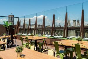 een rij tafels en stoelen op een dak bij Kabul Party Hostel Barcelona in Barcelona