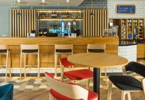a restaurant with a table and chairs and a bar at Holiday Inn Express Bristol City Centre by IHG in Bristol +15 photos
