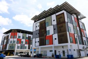 a building with different colored windows on a street at Hotel Mirage PD in Port Dickson