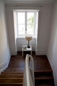 a staircase with a window and a chair in a room at WW Hostel & Suites in Coimbra
