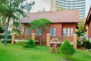 ein kleines rotes Haus mit einem Rad im Hof in der Unterkunft Vung Tau Intourco Resort in Vũng Tàu