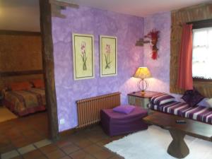 sala de estar con paredes de color púrpura y sofá en Posada Rumoroso, en Rumoroso
