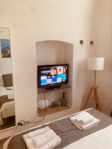 a room with a tv and a bed with a mirror at white house in Bari