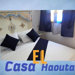 a bedroom with a bed with blue and white pillows at Casa El Haouta in Chefchaouene