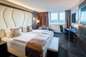 um quarto de hotel com uma cama grande e uma secretária em Best Western Plus Plaza Hotel Darmstadt em Darmstadt