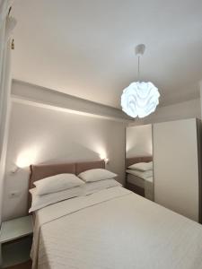 - une chambre avec un grand lit blanc et une lumière dans l'établissement Apartments Karla, à Bibinje