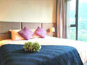 a bedroom with a bed with purple and orange pillows at ELECTUS HOME at Vista Residences Genting - FREE WiFi & TV Box & Parking in Genting Highlands