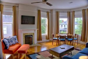 sala de estar con chimenea, mesa y sillas en Newly Renovated Stunning Space, en Savannah