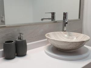 a bathroom with a bowl sink and two vases at Apartamento Morisco in Toledo