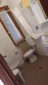 uma casa de banho com um WC e um lavatório em Albergo Legazzuolo Montecampione em Artogne