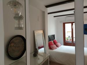une chambre avec un lit et un miroir dans l'établissement Apartamento Morisco, à Tolède