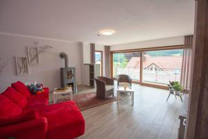 ein Wohnzimmer mit einem roten Sofa und einem Tisch in der Unterkunft Ferienwohnung Habermehl in Oppenau