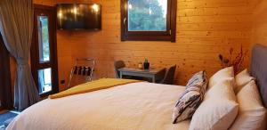 a bedroom with a bed in a log cabin at Cosy Cabin in the Paddocks - Breakfast Included in Franz Josef