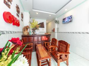 um quarto com cadeiras, uma mesa e flores em OYO 828 Hoa Giay Hotel em Nha Trang