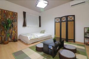 1 dormitorio con cama, mesa y taburetes en Cozy enjoyment hotel no.29 en Kioto