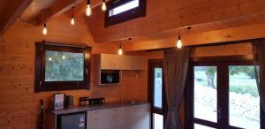 a kitchen in a log cabin with lights on the ceiling at Cosy Cabin in the Paddocks - Breakfast Included in Franz Josef
