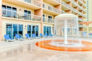a fountain in front of a building with blue chairs at Sunrise Beach Resort V in Panama City Beach