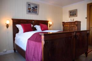 Un dormitorio con una gran cama de madera con almohadas rojas en Strømnes - Oldefars gjestehus Inderøy en Straumen