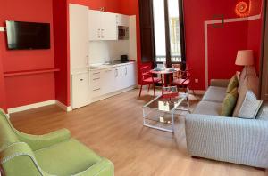 a living room with red walls and a couch and a table at Ritual Sevilla Suites Centro in Seville