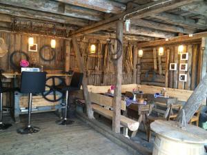 a room with tables and chairs in a wooden building at Strømnes - Oldefars gjestehus Inderøy in Straumen