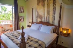 1 dormitorio con 1 cama grande con sábanas blancas en Habitation du Comté, en Sainte-Rose 37 fotos más