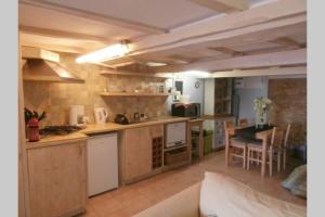 a large kitchen with a couch and a table at The Studio in Hautefort