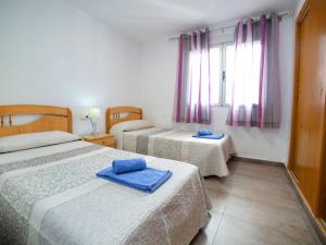 um quarto com 2 camas com toalhas azuis em Apartment Primum by Interhome em Calpe