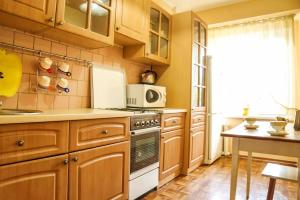 a kitchen with wooden cabinets and a stove top oven at "Арбат" Центр квартира- Apartment "Arbat" in Almaty