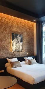 a bedroom with a large bed with a brick wall at Goodnight Antwerp in Antwerp