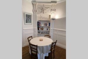 博恩的住宿－Le Jeu de Paume à Beaune centre，一间配备有白色桌椅的用餐室