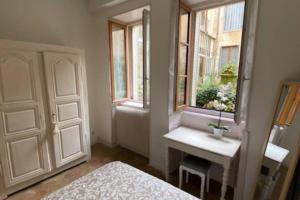 een slaapkamer met een bed, een tafel en een raam bij Le Jeu de Paume à Beaune centre in Beaune +2 foto's