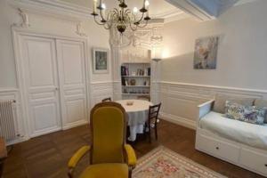 uma sala de estar com uma mesa e um sofá em Le Jeu de Paume à Beaune centre em Beaune