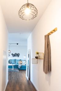 a living room with a blue couch and a light fixture at NEU-Luxus Apartment-Zentral 350m Altstadt-2Zi-65qm in Augsburg
