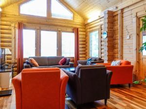 a living room with couches and chairs and windows at Holiday Home Luosto villa d in Luosto