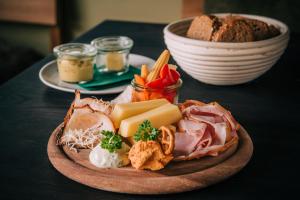 a plate of food with cheese and other foods on a table at Vienna House by Wyndham MQ Kronberg in Kronberg im Taunus