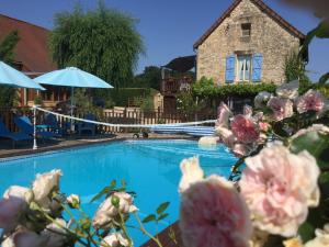 a swimming pool with flowers in front of a house at The Studio in Hautefort +11 photos