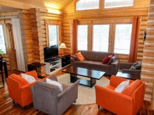 a living room with couches and a tv in a cabin at Holiday Home Luosto villa d in Luosto