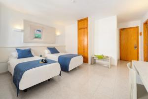 a hotel room with two beds and a table at Apartamentos Vibra Panoramic in Ibiza Town