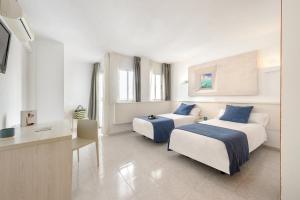 a hotel room with a bed and a desk at Apartamentos Vibra Panoramic in Ibiza Town