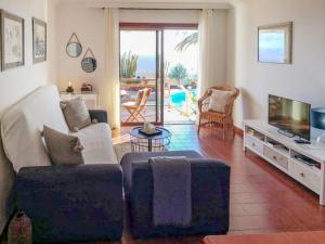 een woonkamer met een bank en een televisie bij Apartment Antequera by Interhome in Radazul