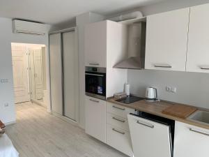 a kitchen with white cabinets and a counter top at Summer Apartments Kabakum by Flat Manаger in Golden Sands